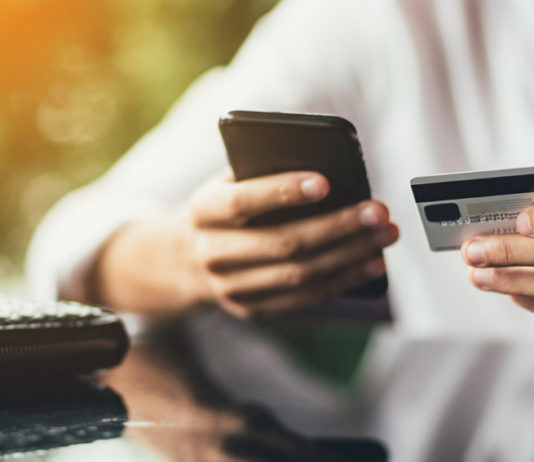 Pagamento della tassa regionale sulla caccia in Lombardia, la nota del Cuav Pagamento della tassa regionale sulla caccia in Lombardia: uomo con carta di credito e smartphone