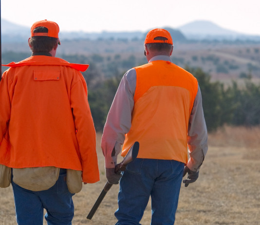 Associazione unica dei cacciatori, la richiesta dell’Arcicaccia Associazione unica dei cacciatori: due cacciatori di spalle indossano gilet arancio alta visibilità