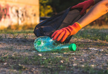 Diffuso il bilancio sociale 2022 della Federcaccia: impatto raddoppiato Diffuso il bilancio sociale 2022 della Federcaccia: mano con guanto raccoglie bottiglia di plastica per pulire la foresta e introdurla nel sacco nero della spazzatura